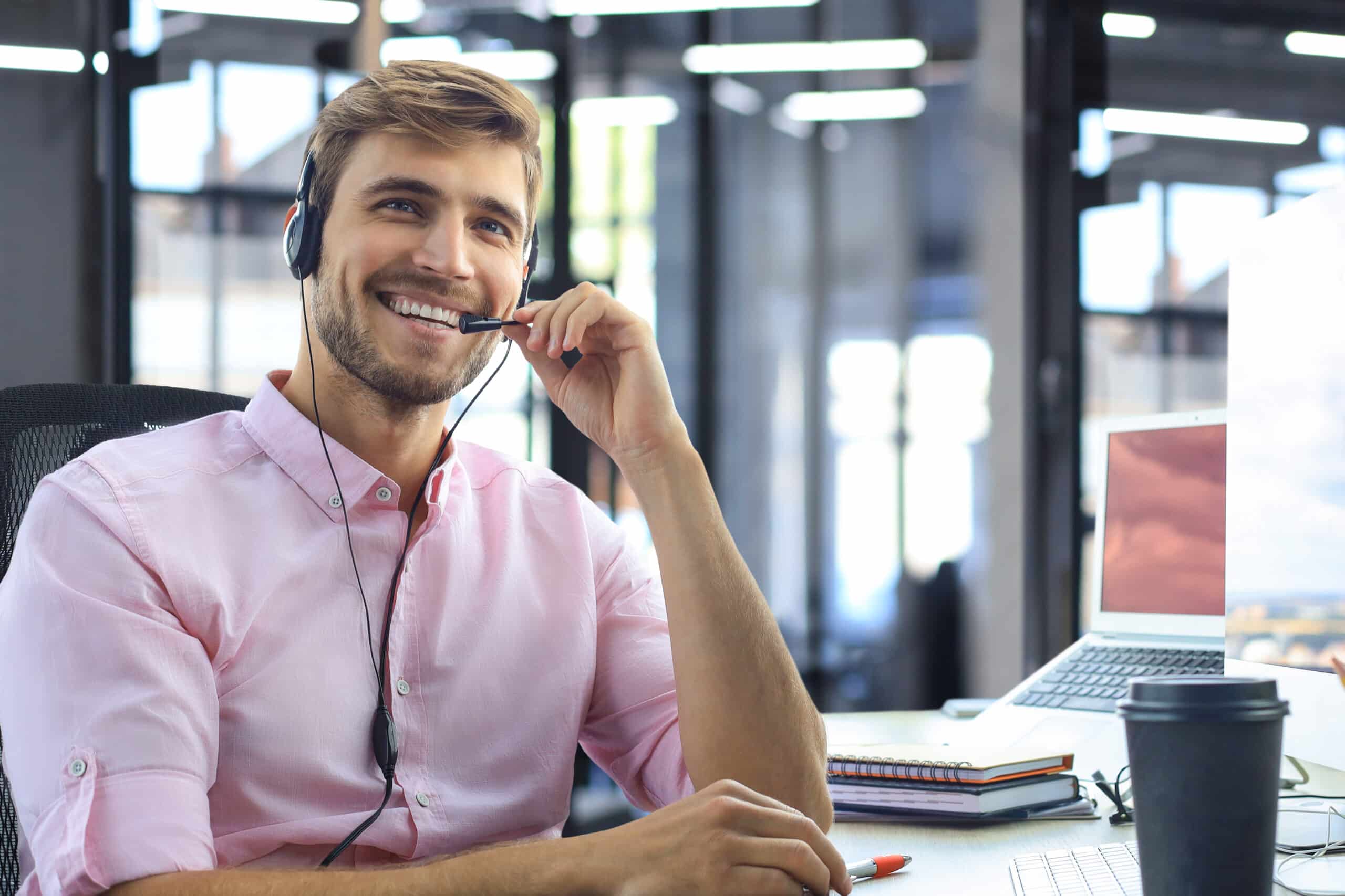 Smiling friendly handsome young male call centre operator. Customer support for Next Stage Payment solutions